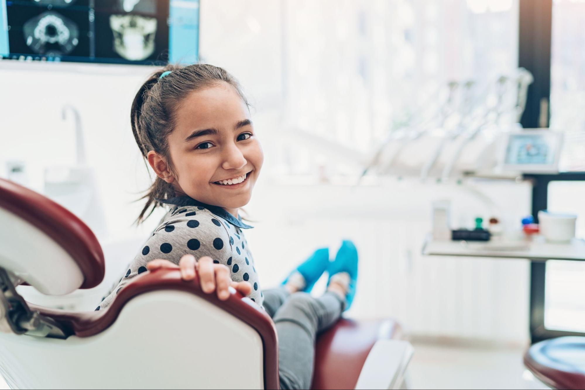 Young girl smiling in a dental chair during her visit to a Memphis pediatric dentist